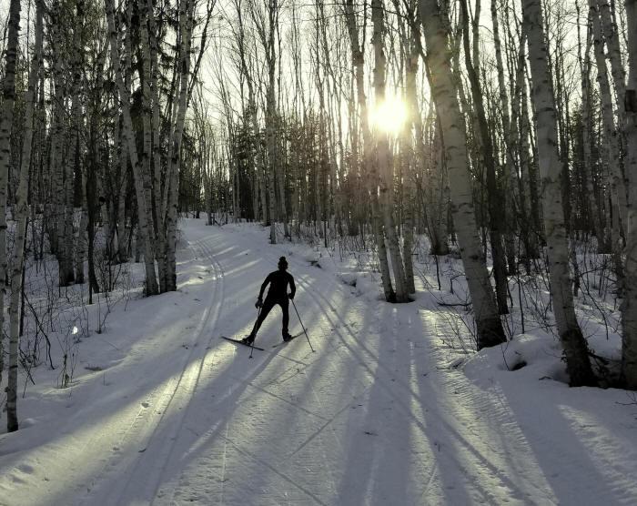 Skieur s'éloignant au coucher de soleil